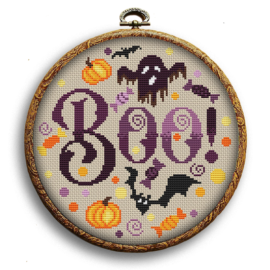 A cross stitch pattern depicting the word 'BOO!' in a Halloween-themed design with pumpkins, bats, and ghosts.