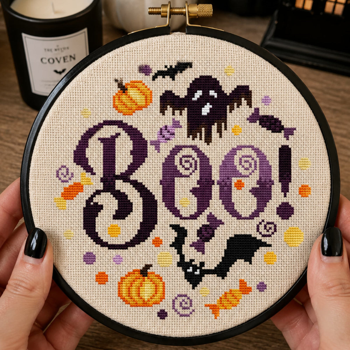 Boo Halloween cross stitch pattern PDF displayed in embroidery hoop, cute spooky ghost and bat embroidery design.