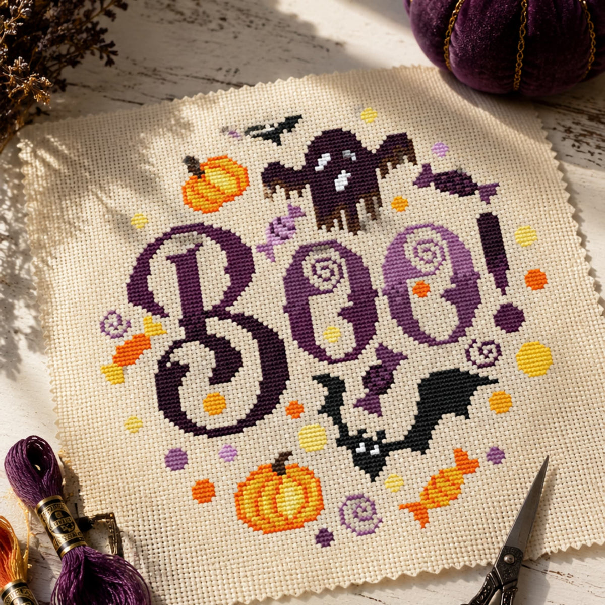 Boo Halloween cross stitch pattern PDF with pumpkins, bats and ghost, spooky modern embroidery design on fabric.