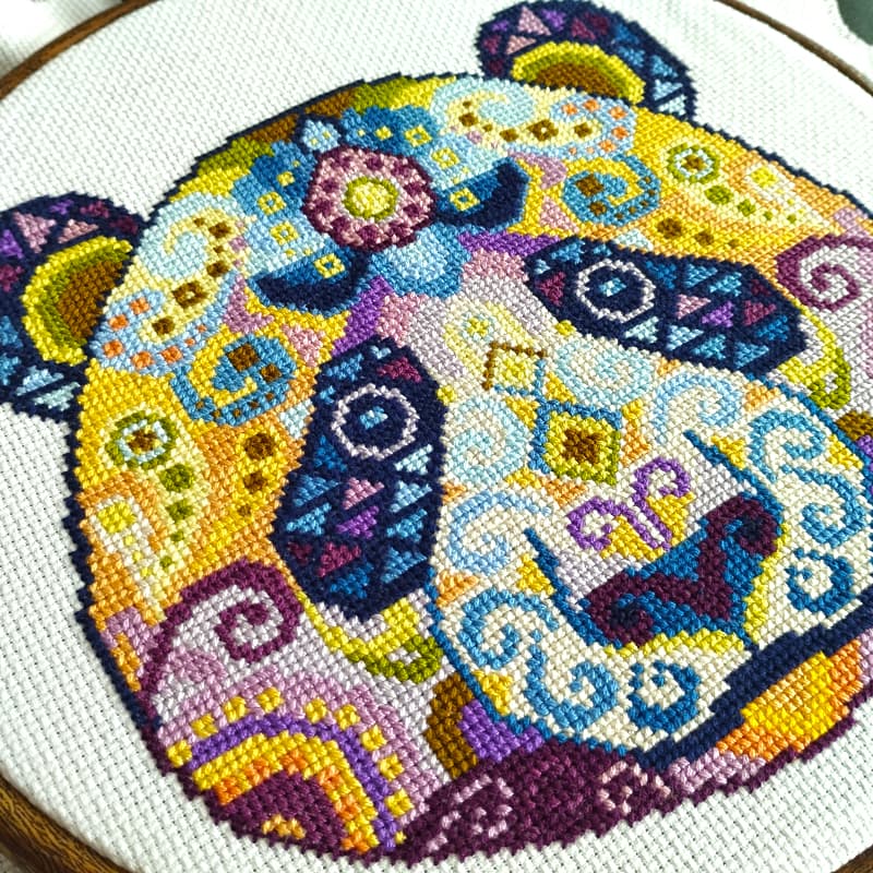 Close up detail of a colorful panda cross stitch