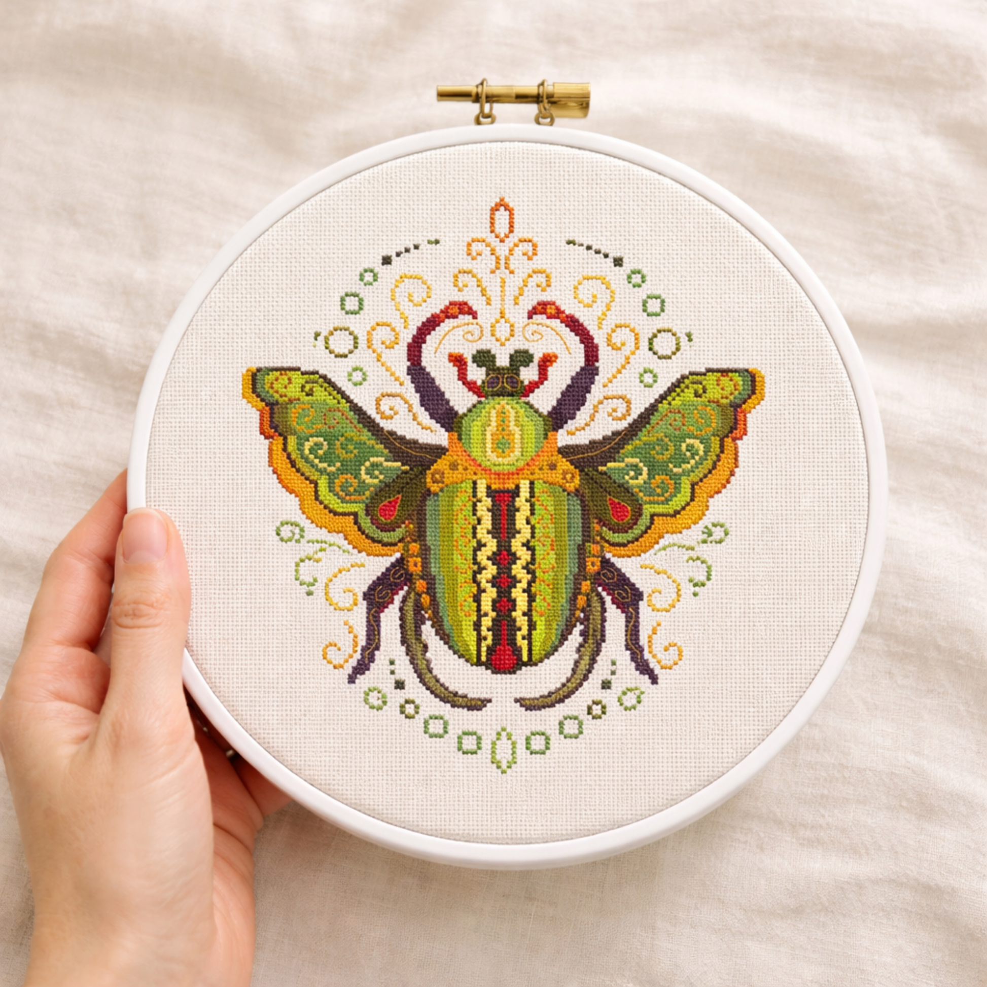 Embroidery hoop with a colorful beetle cross stitch design 