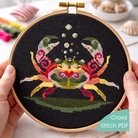 Colorful crab cross stitch pattern PDF displayed in embroidery hoop on black Aida fabric, modern folk ocean crab embroidery design digital download