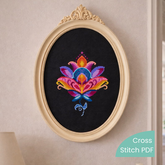 Colorful folk lotus cross stitch embroidery framed in an elegant oval frame, displayed as wall art on a light interior wall.