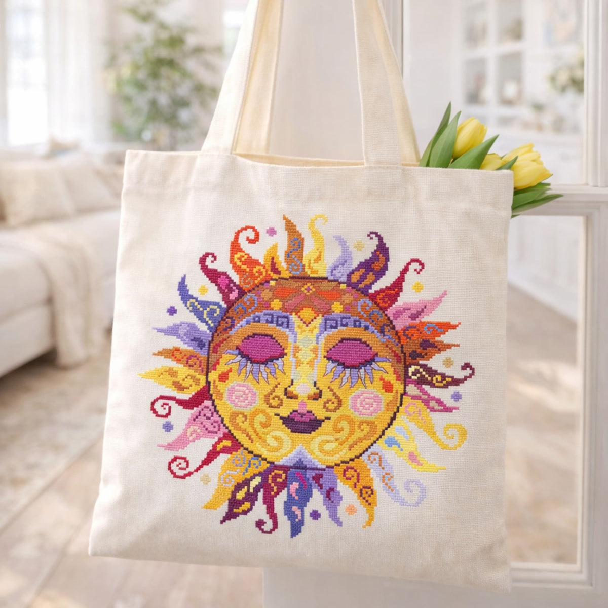 Colorful swirl sun counted cross stitch kit displayed on canvas tote bag with bright folk embroidery reusable bag design.