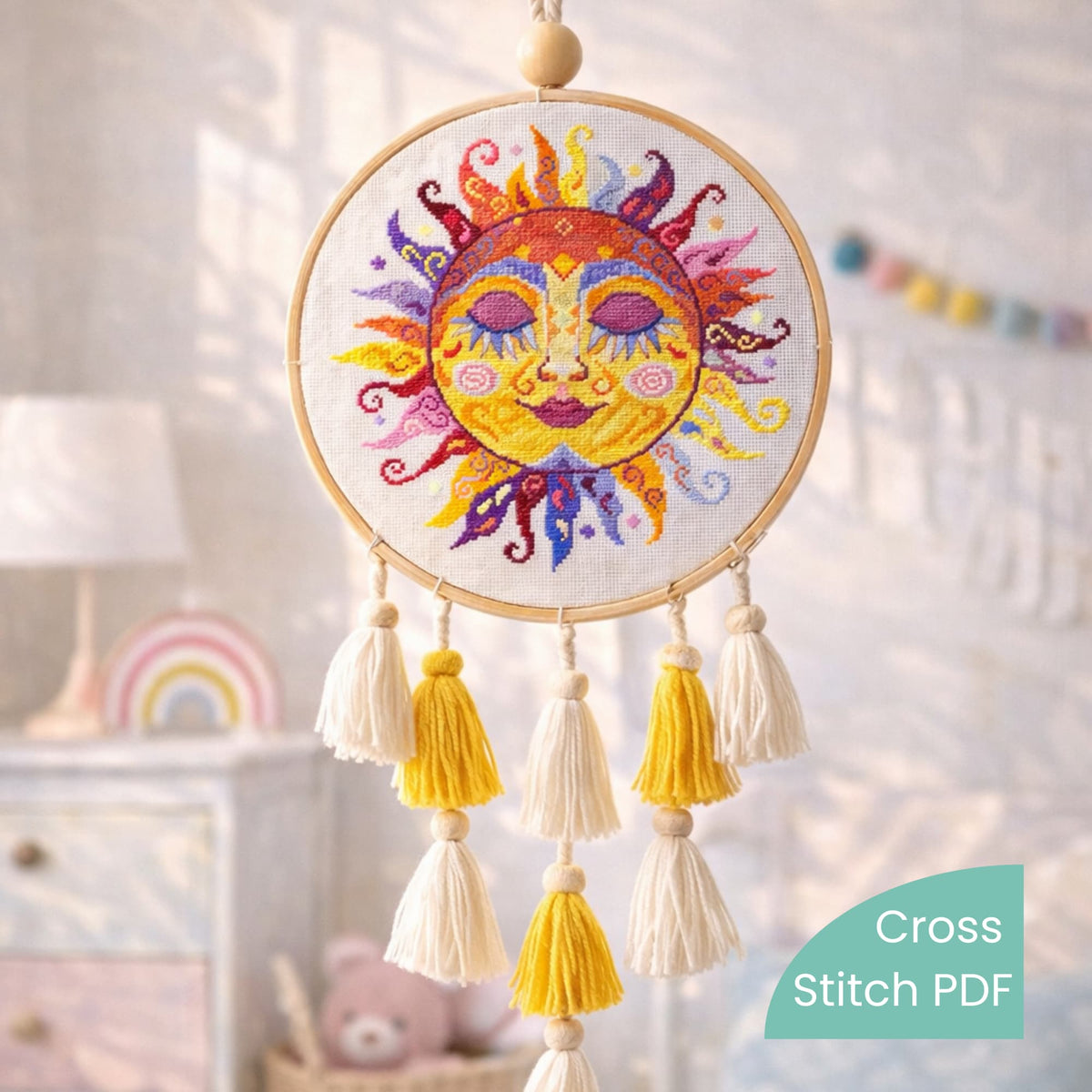 Colorful swirl sun cross stitch pattern displayed in embroidery hoop with tassels, handmade folk sun embroidery wall decoration, child room decor.
