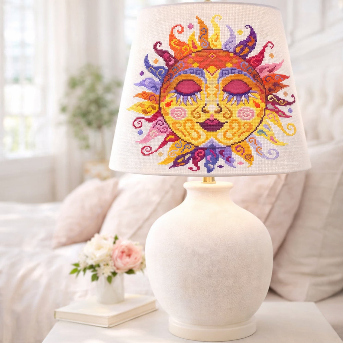 Colorful swirl sun cross stitch pattern featured on decorative lamp shade, artistic folk embroidery home decor design