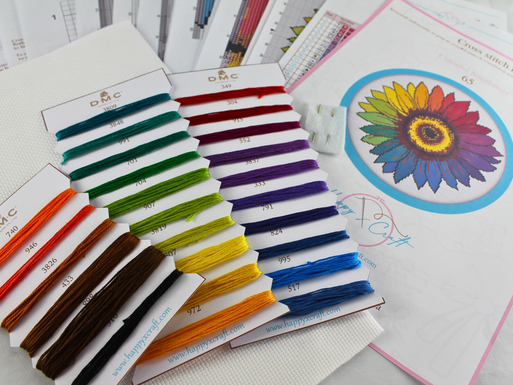 Colorful sunflower cross stitch kit with DMC embroidery threads, Aida fabric, needles, and printed charts, ready for stitching