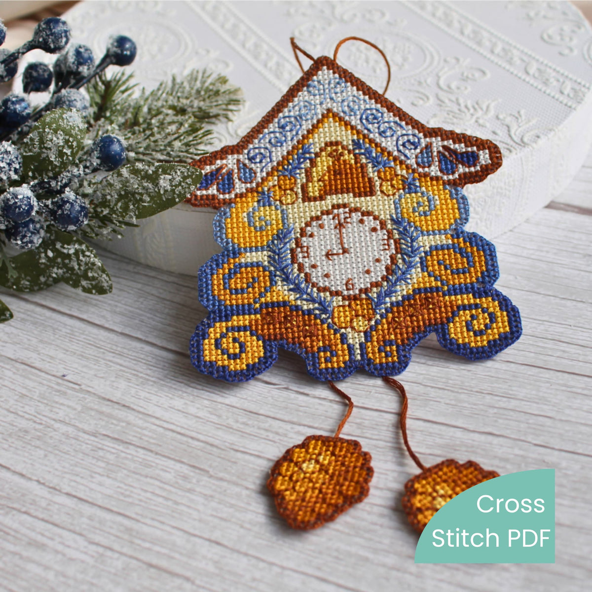 Cross-stitched Christmas Wall clock ornament on a wooden surface with decorative elements.
