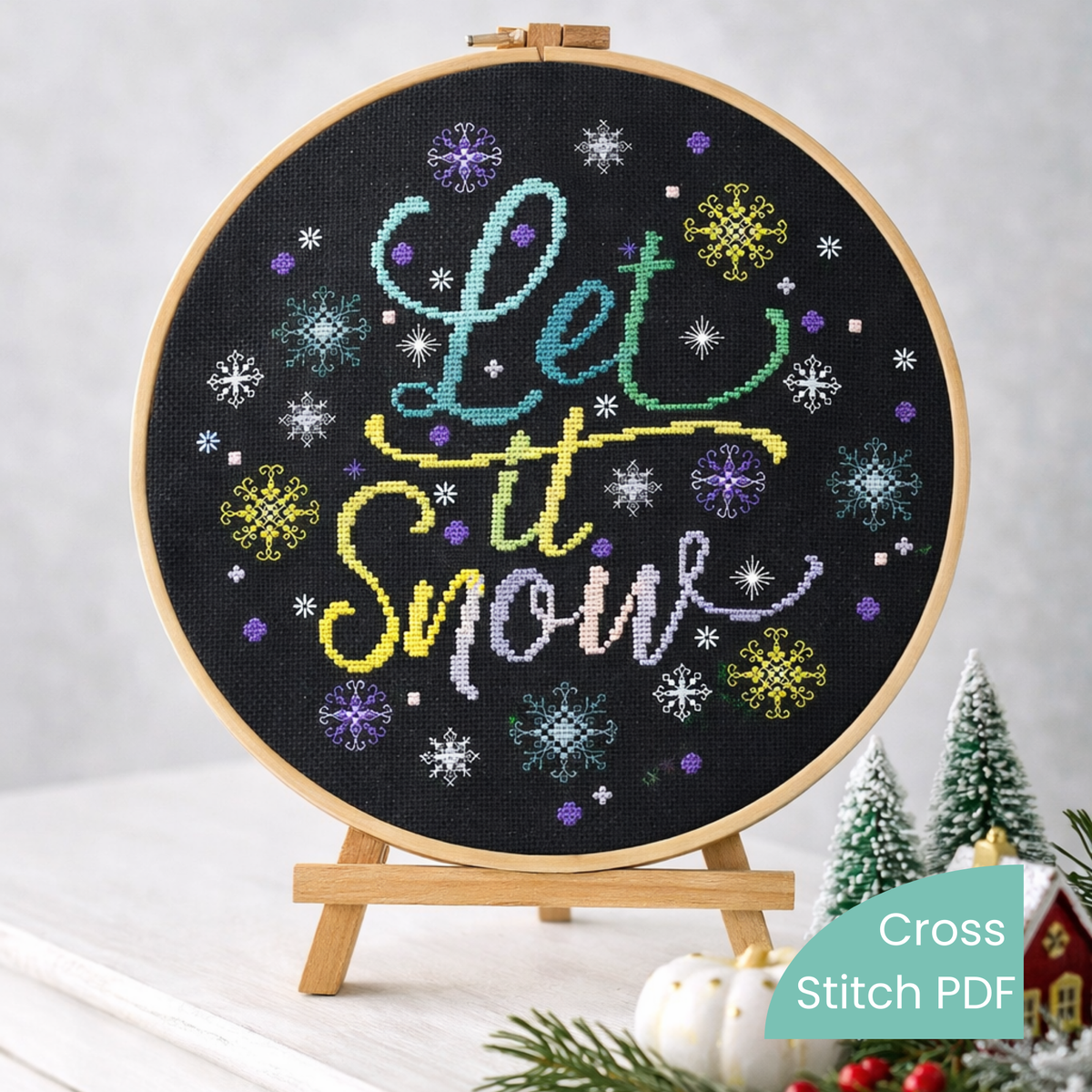 Cross Stitch Pattern Let It Snow PDF – Christmas Snowflake Embroidery Design displayed in wooden embroidery hoop on black Aida