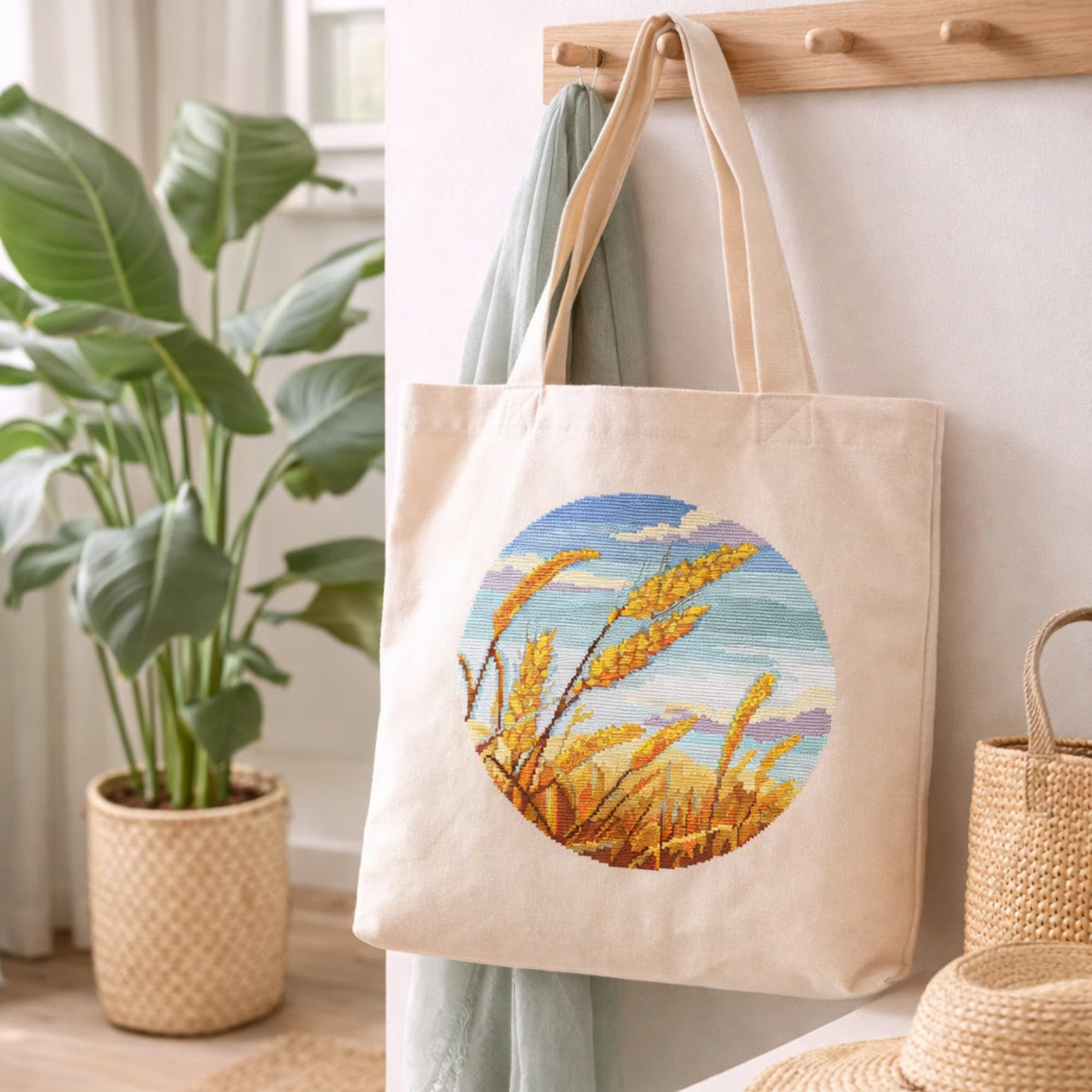 Cross stitch wheat field pattern embroidered on natural cotton tote bag, rustic harvest landscape needlework design, farmhouse style handmade embroidery inspiration.