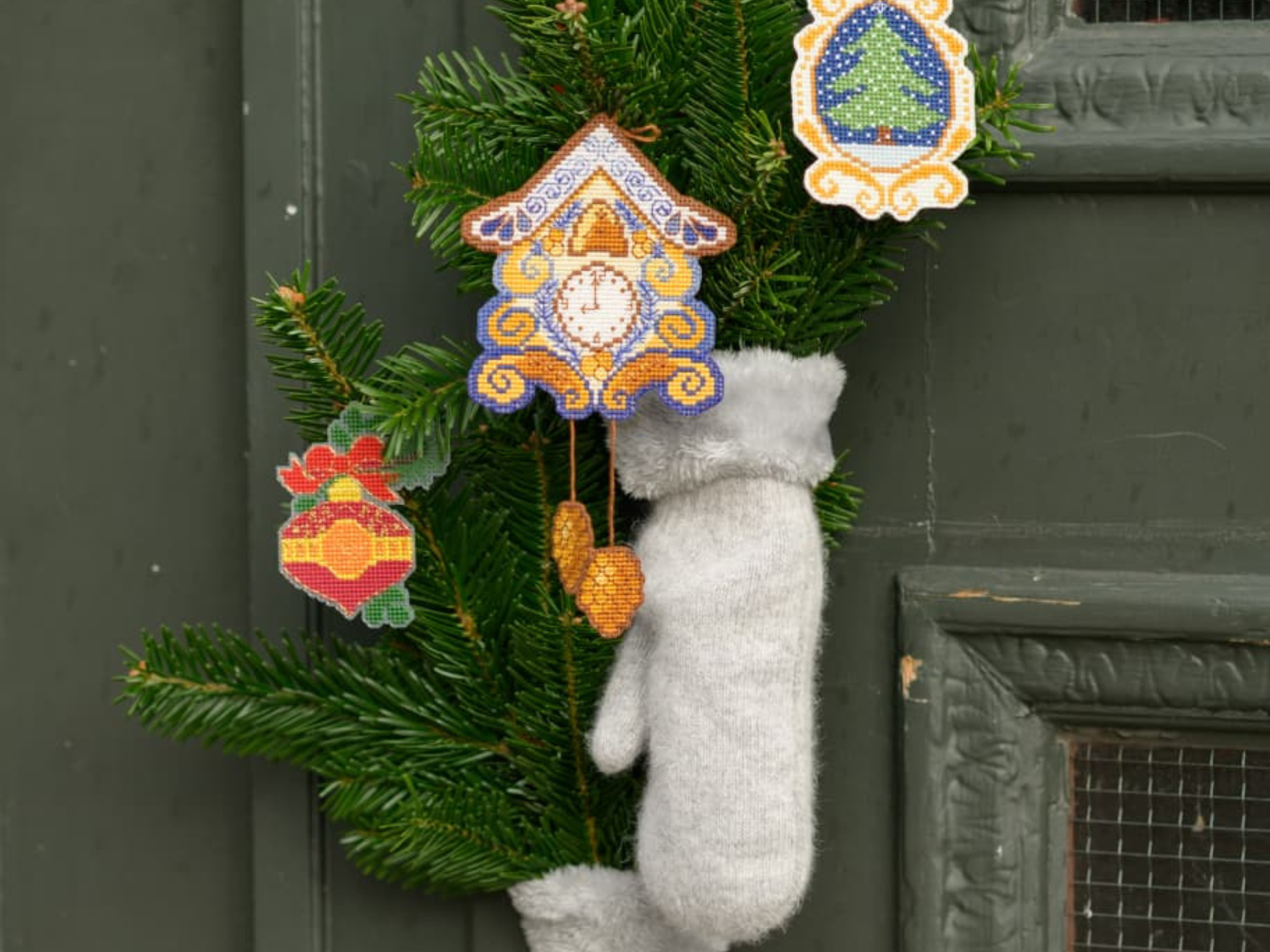 Christmas cross stitched ornaments on canvas hanged on Pine branches