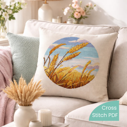 Decorative pillow with wheat field cross stitch embroidery, golden grain landscape needlework pattern, rustic farmhouse style handmade home decor.