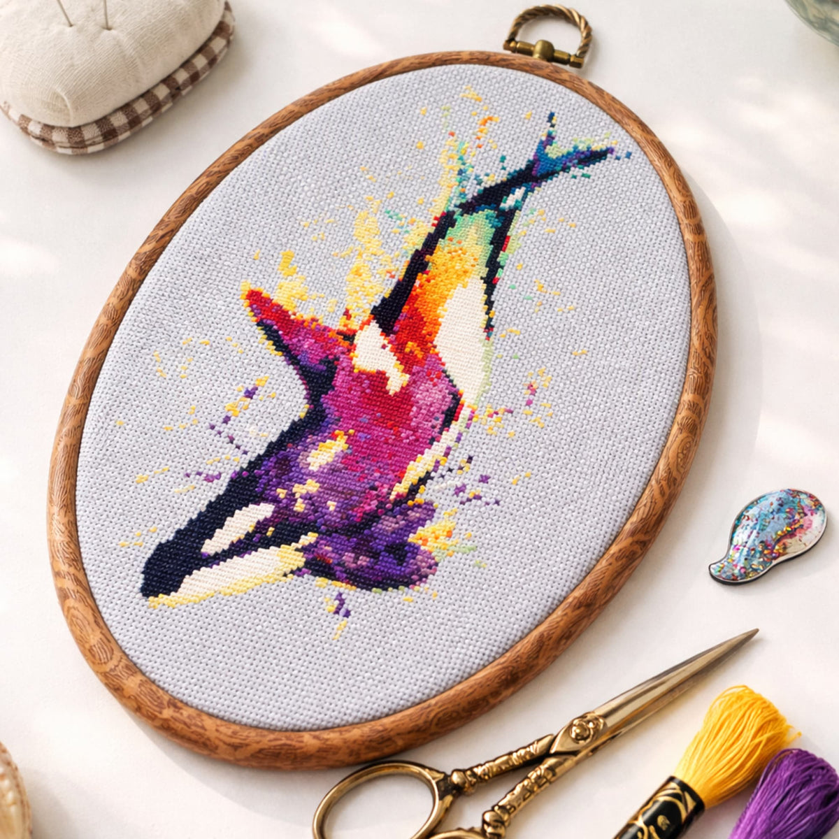 Orca Whale Counted Cross Stitch Kit stitched in oval embroidery hoop with embroidery threads and scissors, modern whale needlework kit.
