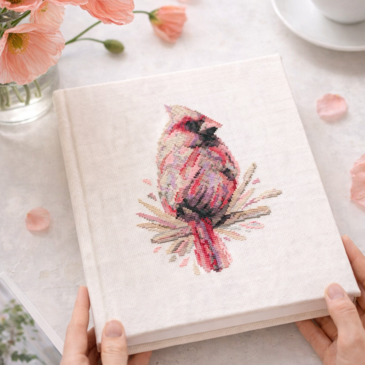 Female cardinal counted cross stitch pattern stitched on fabric cover notebook, realistic wildlife embroidery example from PDF chart.