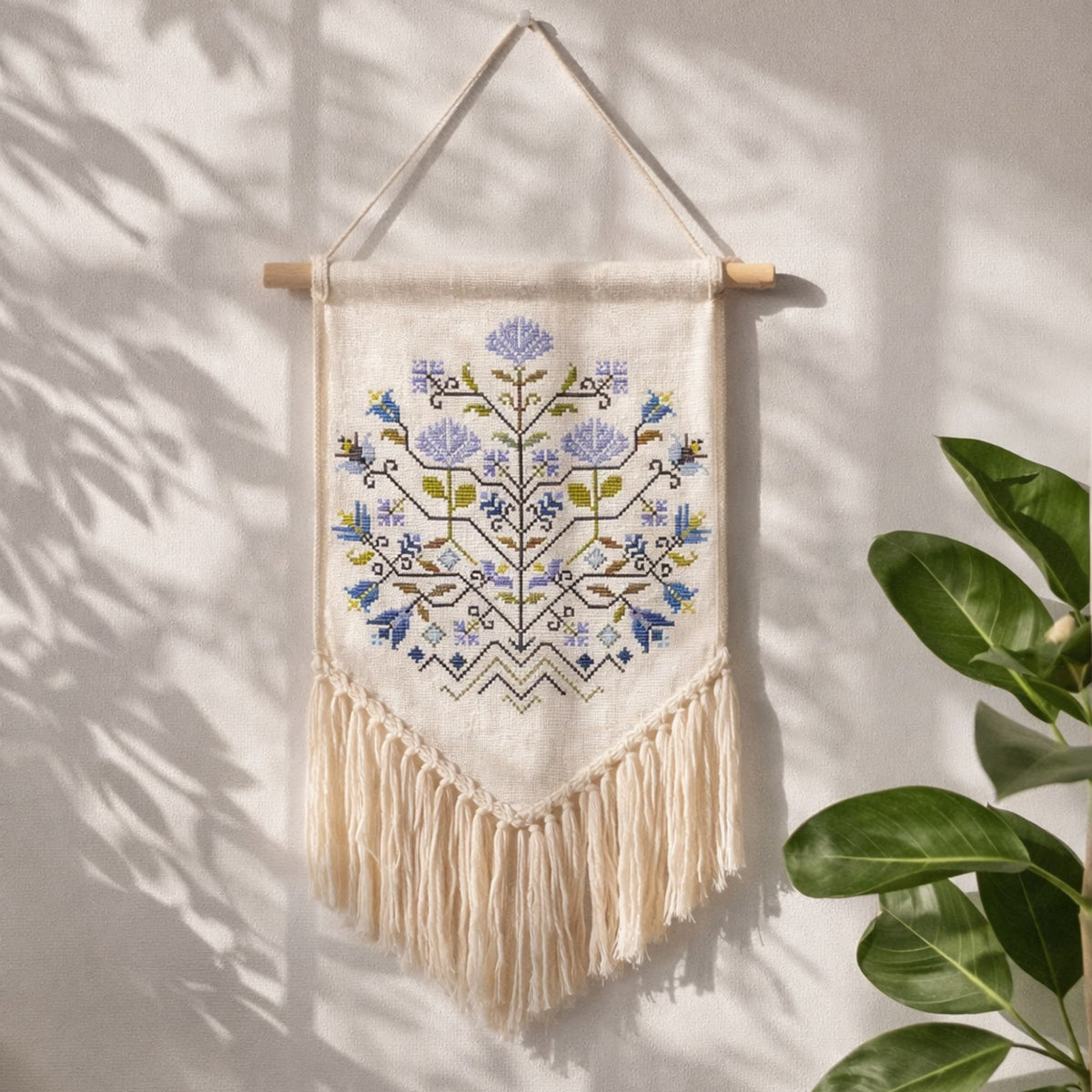 Finished cross stitch wall hanging with Blue Flowers Sampler folk floral design. Example of completed embroidery stitched using the cross stitch pattern PDF. Traditional botanical counted cross stitch decor.