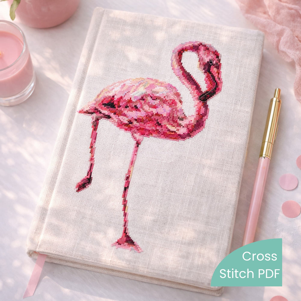 Flamingo Cross Stitch Pattern PDF displayed on embroidered notebook cover with pink flamingo design, modern bird counted cross stitch pattern.