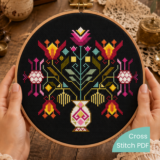 Folk Cross-stitched floral design in a wooden hoop on a wooden surface.