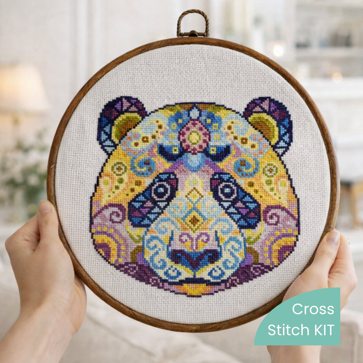 Folk modern panda counted cross stitch kit displayed on decorative pillow with colorful mandala animal embroidery design.
