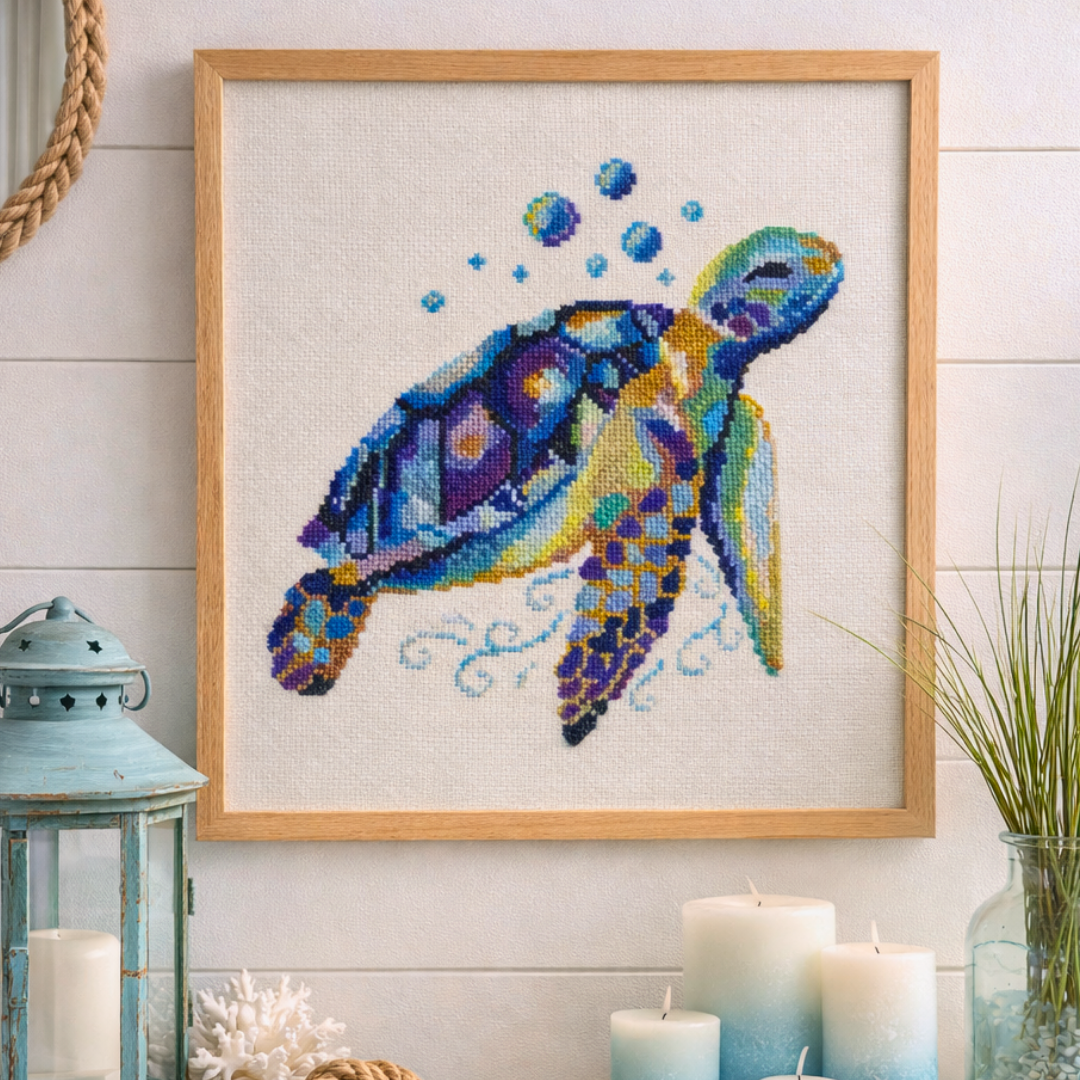 Framed sea turtle cross stitch artwork displayed as coastal wall decor with soft beach-inspired styling
