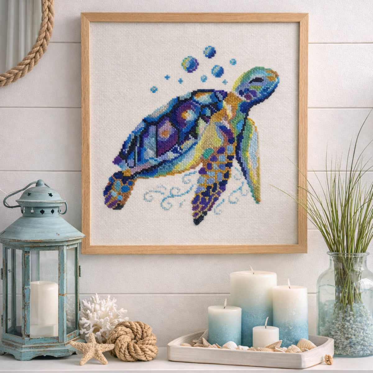 Framed sea turtle cross stitch artwork displayed as coastal wall decor with soft beach-inspired styling