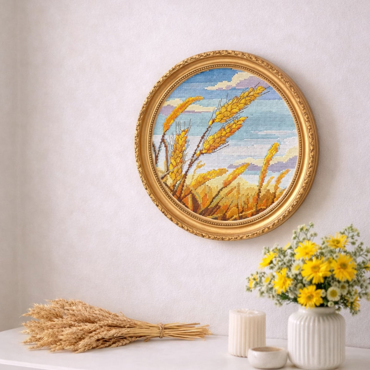 Framed wheat field cross stitch artwork, circular harvest landscape embroidery design, rustic countryside needlework wall decor.