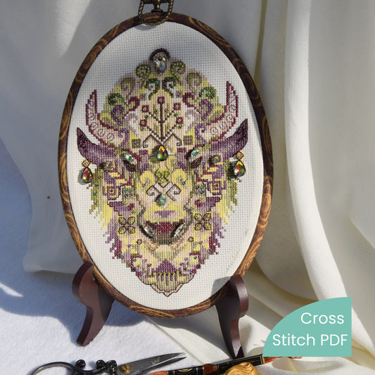 Geometric bison cross stitch pattern displayed in oval wooden frame, intricate modern tribal animal embroidery with beads and crystals, digital PDF pattern
