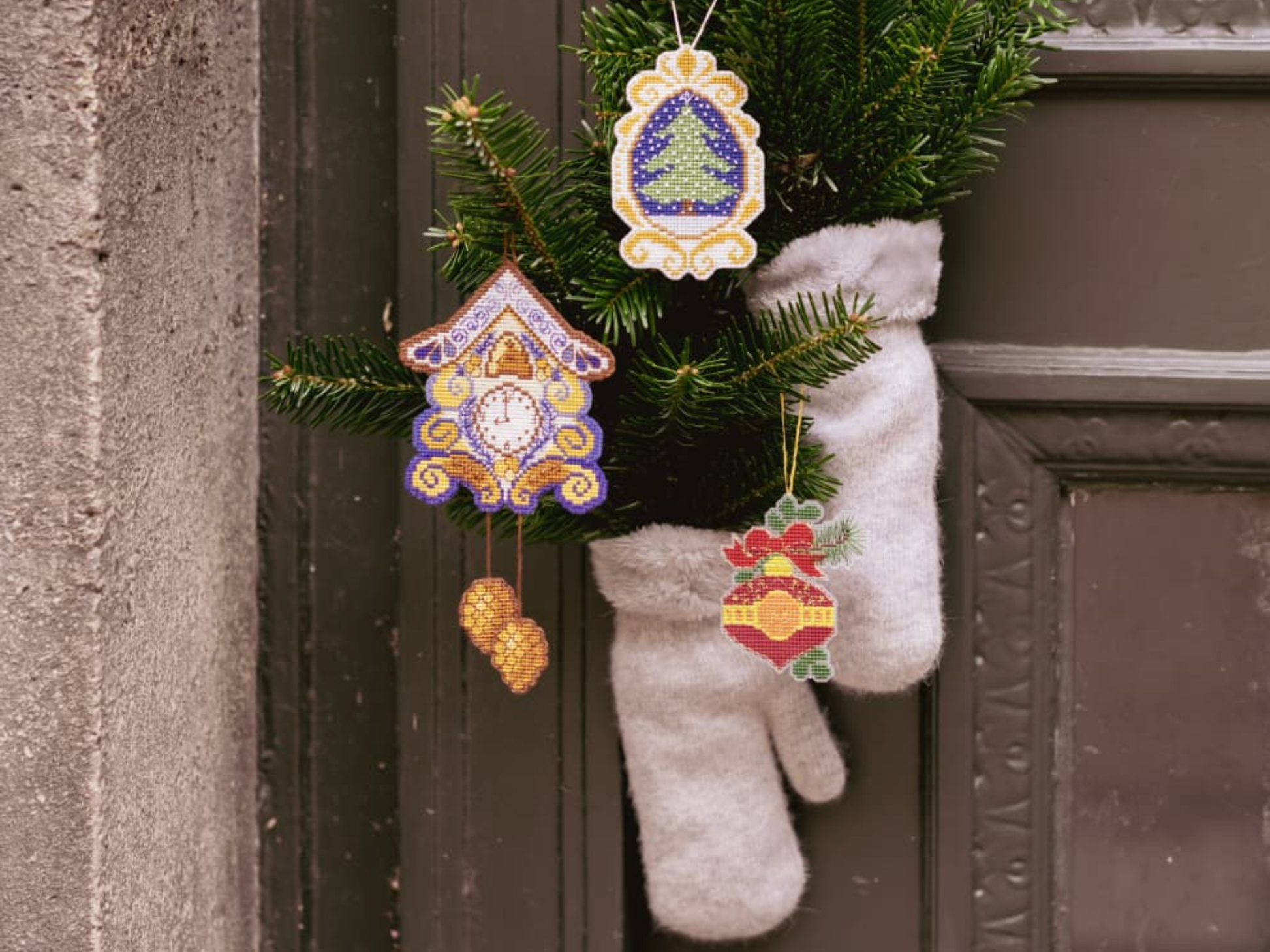 Christmas cross stitched ornaments on canvas hanged on Pine branches