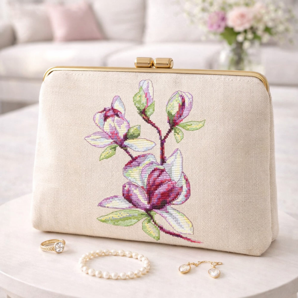 Magnolia cross stitch kit stitched on linen clutch bag, delicate pink flower embroidery, finished sample shown as example.
