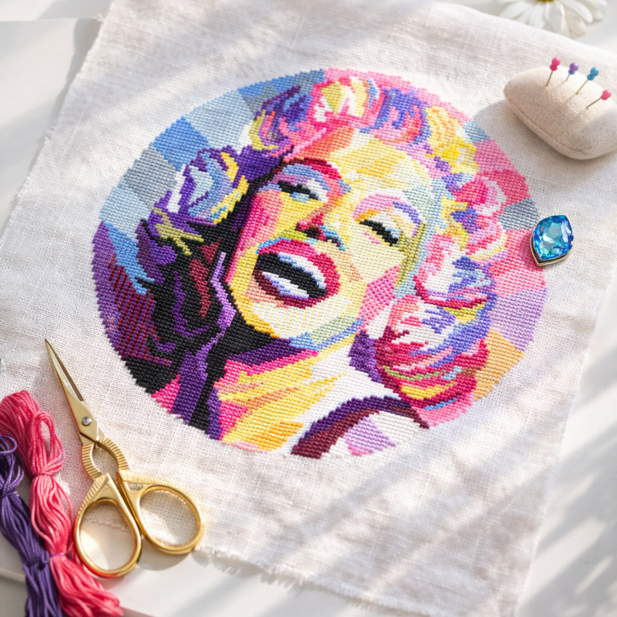 Marilyn Monroe Cross Stitch Pattern PDF digital download showing finished portrait embroidery with threads, scissors and needlework tools.