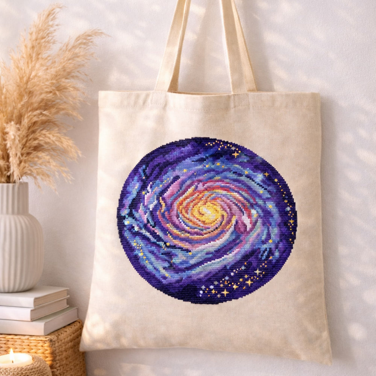 Milky Way Galaxy Counted Cross Stitch Kit displayed on tote bag, cosmic spiral galaxy embroidery kit, colorful space needlework set.