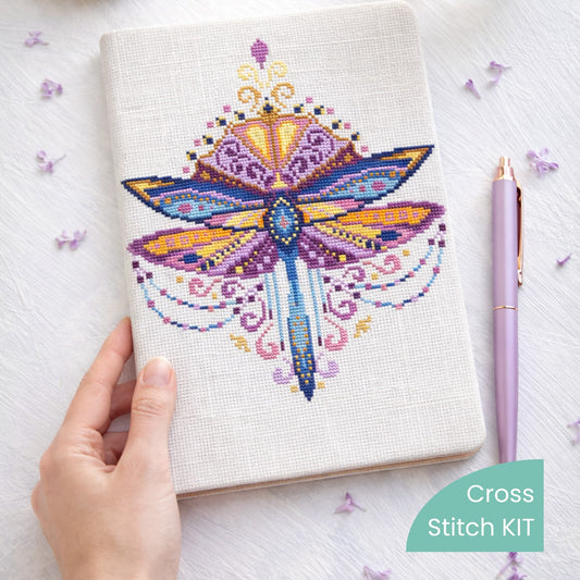 Purple Dragonfly Counted Cross Stitch Kit showing decorative dragonfly embroidery stitched on fabric notebook cover.