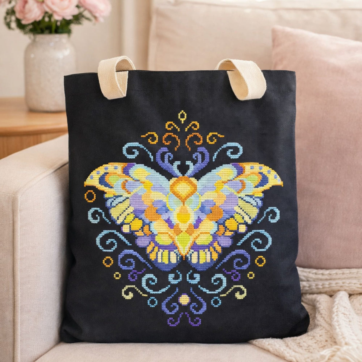 Purple Moth Counted Cross Stitch Kit featuring vibrant butterfly embroidery stitched on black cotton tote bag.