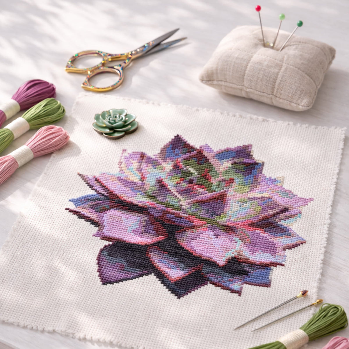 Purple Succulent Counted Cross Stitch Kit showing stitched succulent embroidery on fabric with embroidery threads and scissors.