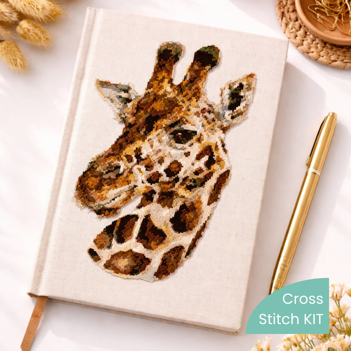 Realistic giraffe counted cross stitch kit displayed on notebook cover with detailed safari animal embroidery design.