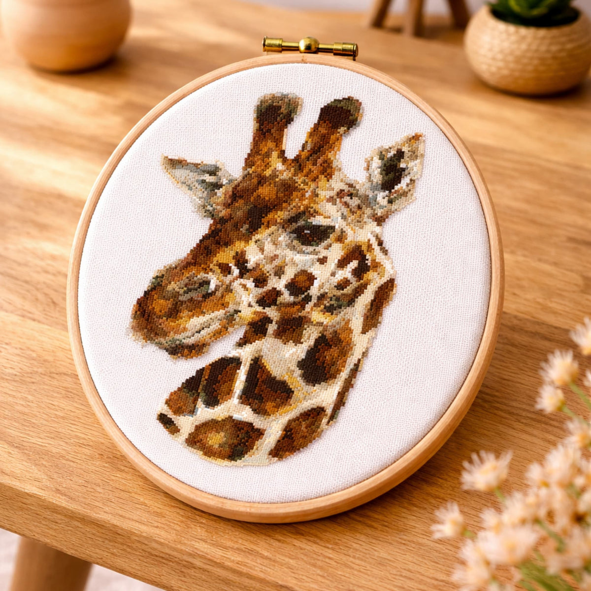 Realistic giraffe counted cross stitch kit shown in embroidery hoop with natural animal portrait design.