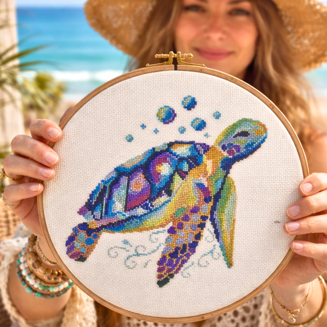 Sea turtle counted cross stitch finished piece held in wooden embroidery hoop, seaside background