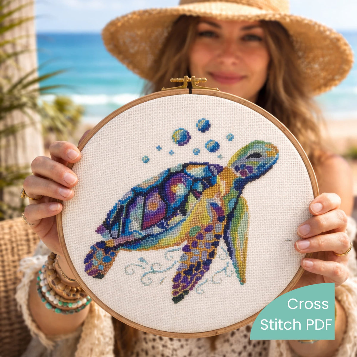 Sea turtle counted cross stitch finished piece held in wooden embroidery hoop, seaside background