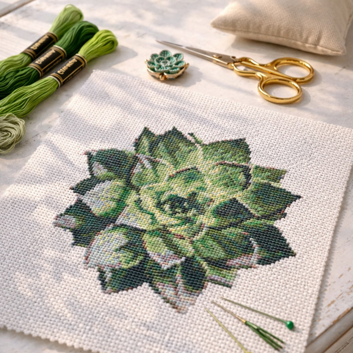 Succulent cross stitch pattern PDF, botanical embroidery design stitched on fabric with threads and scissors, nature inspired embroidery project for DIY plant themed stitching