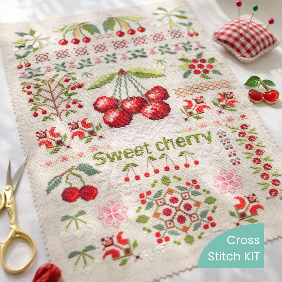 Sweet cherry cross stitch kit with threads, scissors and accessories showing botanical fruit sampler embroidery design.