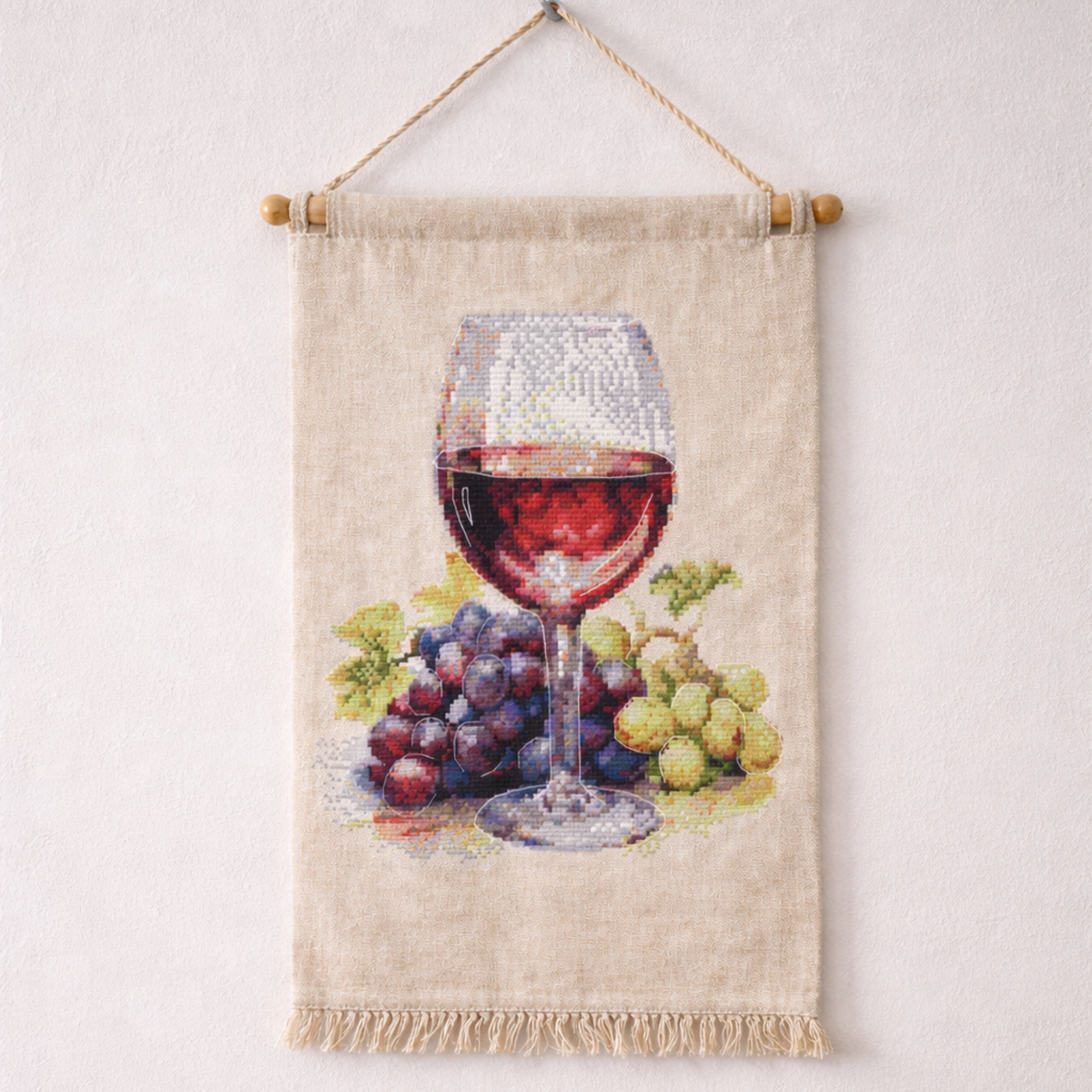 Wine glass and grapes cross stitch kit displayed as decorative wall hanging embroidery, realistic wine still life DIY project