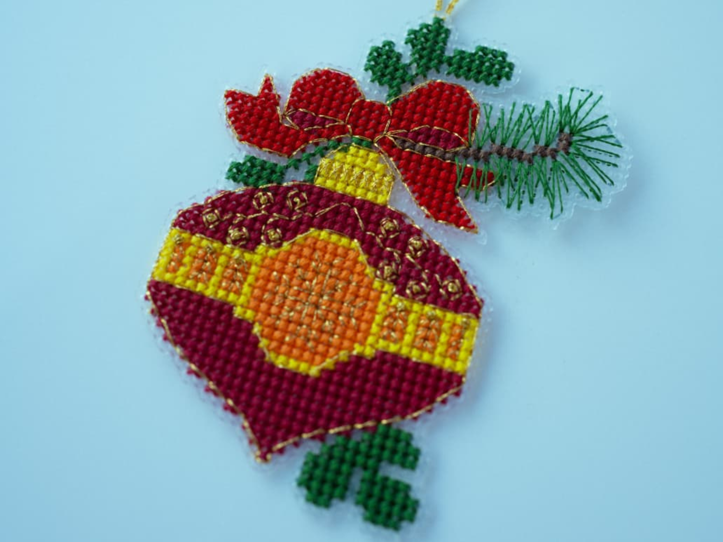 Cross-stitched ornament with red and yellow elements