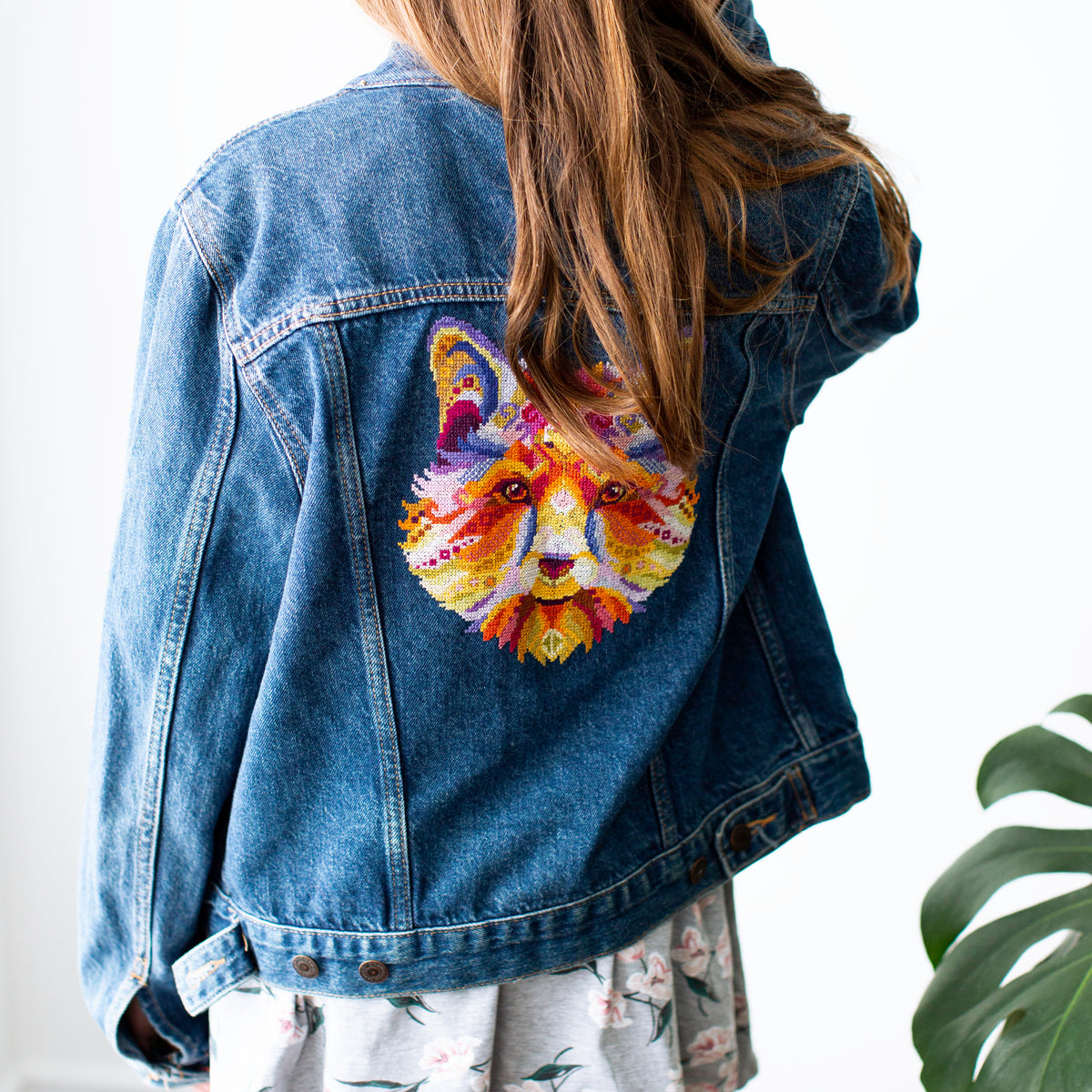 Colorful swirl fox counted cross stitch kit featured on stylish denim jacket with vibrant folk fox embroidery design.