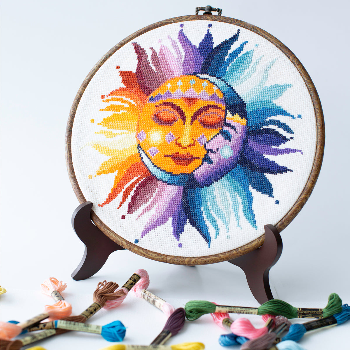 Sun and moon cross stitch kit finished design in embroidery hoop on white Aida fabric, vibrant celestial sun moon DIY kit
